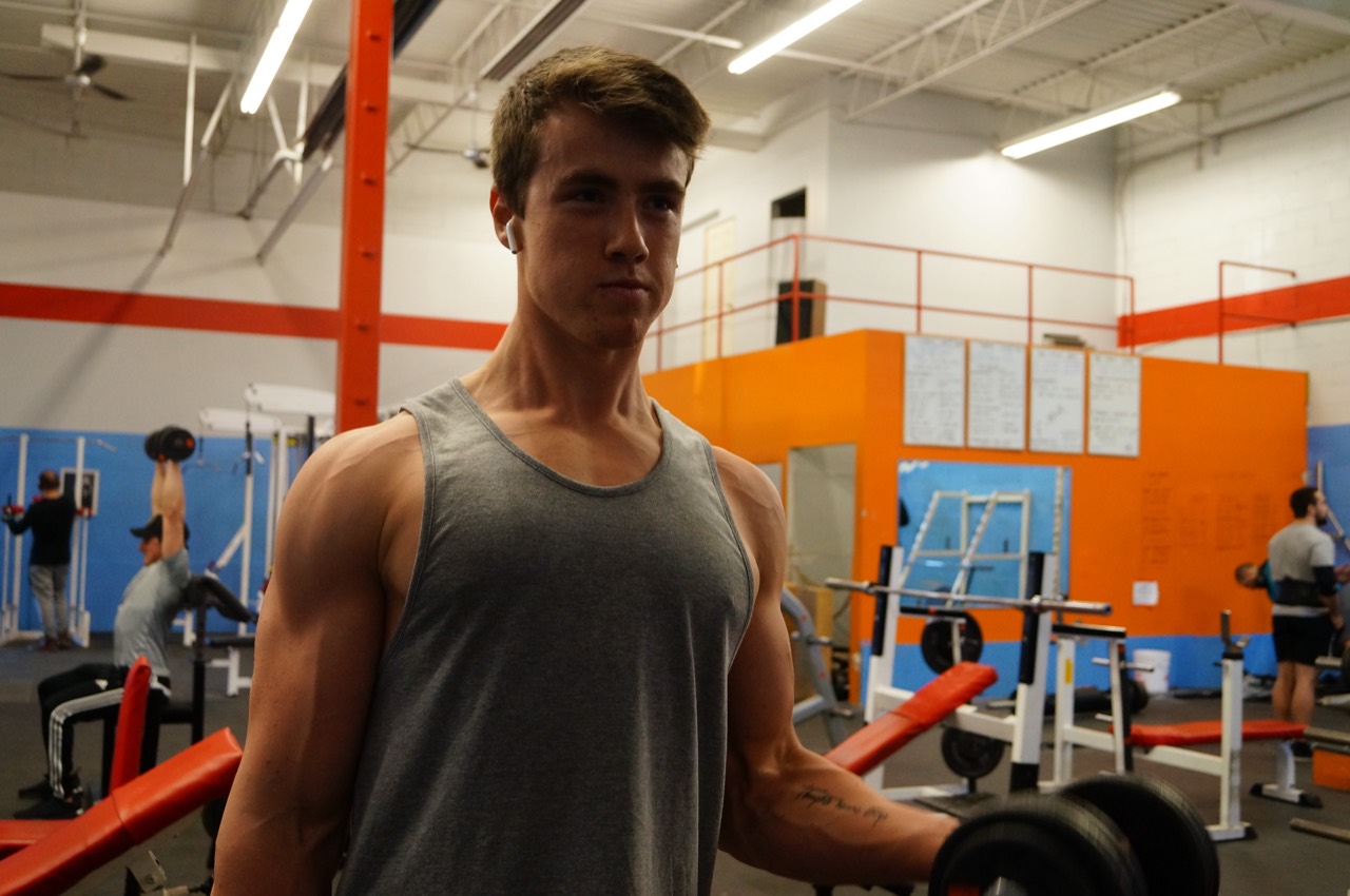 Tyler performing a dumbbell curl during a gym training session
